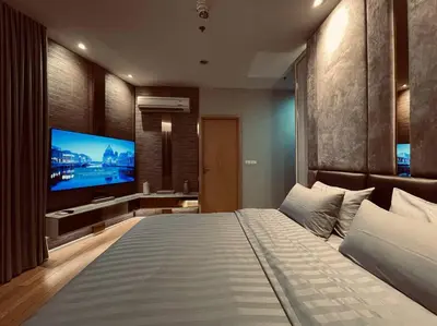 a bedroom with a large bed and a flat screen tv at 2BedRoom-BestLocationBangkok-Emquartier-Metro-PhromPhong in Bangkok
