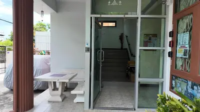 a glass door leading to a stairway with a table at ธิติกาญจน์ อพาร์ทเม้นท์ in Ban Khlong Samrong
