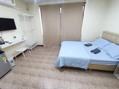 a bedroom with a bed and a desk and a television at ธิติกาญจน์ อพาร์ทเม้นท์ in Ban Khlong Samrong