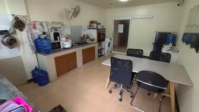 a kitchen with a table and two chairs in it at ธิติกาญจน์ อพาร์ทเม้นท์ in Ban Khlong Samrong