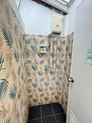 a bathroom with a shower stall with a wall at Comfy Crib Hostel in Bangkok