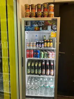 a refrigerator filled with lots of sodas and drinks at Comfy Crib Hostel in Bangkok