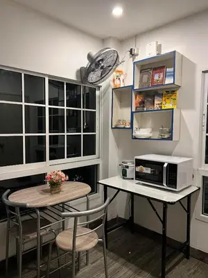 a small kitchen with a table and a microwave at Comfy Crib Hostel in Bangkok