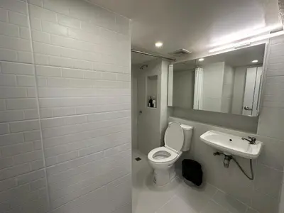 a bathroom with a white toilet and a sink at Letter Better Home in Bangkok