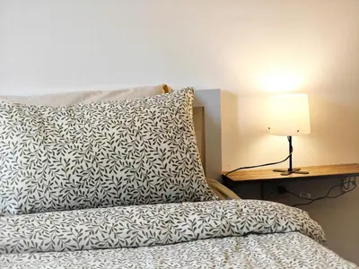 a bed with a pillow and a lamp on a table at homey stay and cafe by hematoa in Bangkok