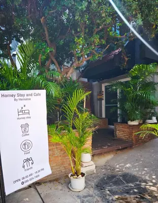 a sign in front of a house with plants at homey stay and cafe by hematoa in Bangkok