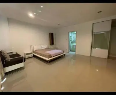 a bedroom with a bed and a couch in it at BKK TEAK Hostel in Amphoe Phra Khanong