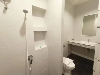a white bathroom with a toilet and a sink at BKK TEAK Hostel in Amphoe Phra Khanong
