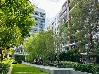 a park in front of some tall buildings at Tierra Residences in Bangkok
