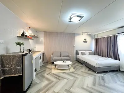 a bedroom with a bed and a couch and a table at NK hostel 31 in Ban Bang Phang