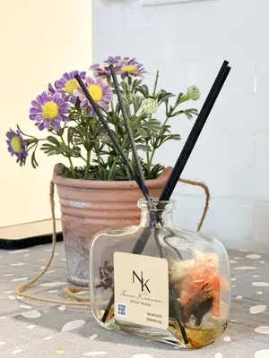 a vase with flowers in it next to a pot of flowers at NK hostel 31 in Ban Bang Phang