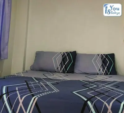 a bed with a blue comforter and two pillows at IsYou Sabye ห้องพักรายวัน รามคำแหง in Ban Zong Katiam
