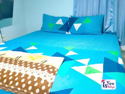 a bed with colorful pillows on top of it at IsYou Sabye ห้องพักรายวัน รามคำแหง in Ban Zong Katiam