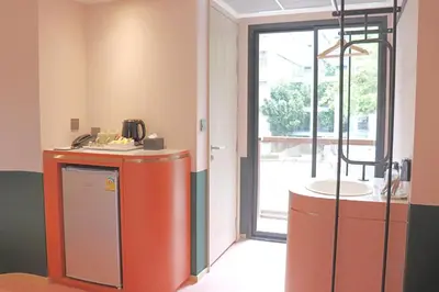 a room with a kitchen with an orange refrigerator at The Quarter Ratchathewi by UHG in Bangkok