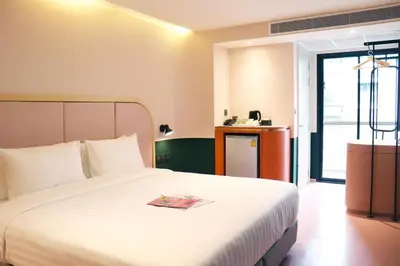 a hotel room with a bed with a book on it at The Quarter Ratchathewi by UHG in Bangkok