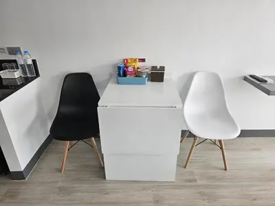 two white desks and two black chairs in a room at โรงแรมแอเรียเพลส สาทร (AREA Place) in Chong Nonsi