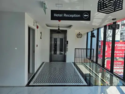 a walkway in a building with a hotel reception sign at โรงแรมแอเรียเพลส สาทร (AREA Place) in Chong Nonsi