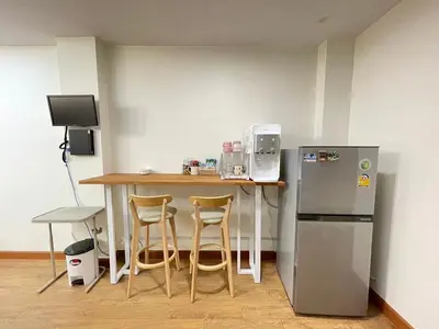 a kitchen with a table and a refrigerator at Modern 5-Bedroom Townhome near MRT and Local Charm in Bangkok