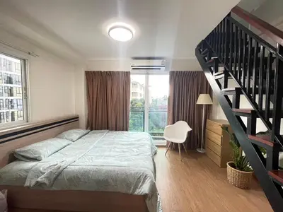 a bedroom with a bed and a spiral staircase at Modern 5-Bedroom Townhome near MRT and Local Charm in Bangkok