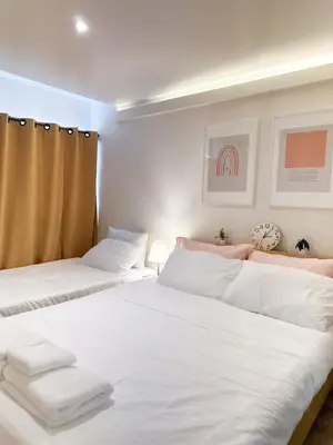 two beds in a room with white sheets at Happiness sleep C3 in Ban Bang Phang