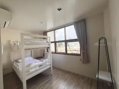 a bedroom with two bunk beds and a window at Krung Tone Hostel in Bangkok