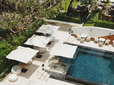 an overhead view of a swimming pool with umbrellas and chairs at Floral Court Hotel & Residence Sukhumvit 13 in Bangkok