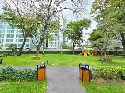 a park with a playground and two trash cans at Floral Court Hotel & Residence Sukhumvit 13 in Bangkok