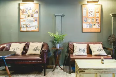 a living room with two leather chairs and a table at Niras Bankoc Hostel in Bangkok