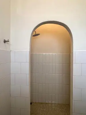 an archway in a bathroom with white tiles at La Moon House in Salaya