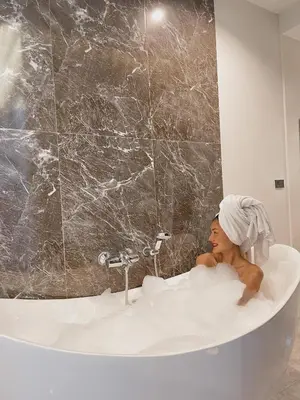 a woman sitting in a bath tub in a bathroom at KVILLA in Ban Khlong Bang Chak