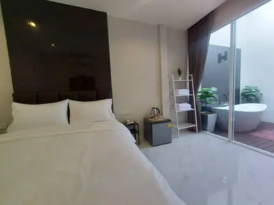 a bedroom with a large bed and a bath tub at KVILLA in Ban Khlong Bang Chak