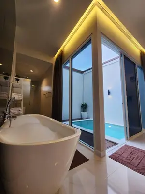 a bathroom with a bath tub and a large window at KVILLA in Ban Khlong Bang Chak
