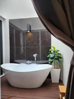 a bath tub in a bathroom with a plant at KVILLA in Ban Khlong Bang Chak