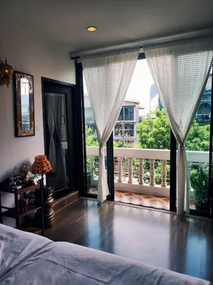 a bedroom with a bed and a view of a balcony at mstay in Bangkok
