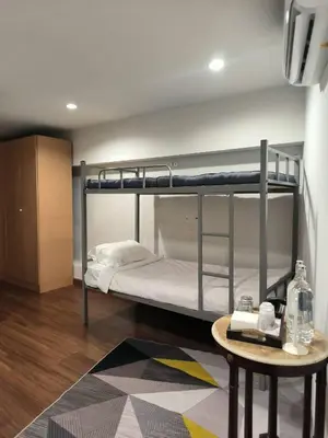 a room with two bunk beds and a table at mstay in Bangkok