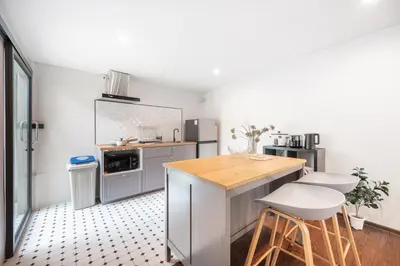 a kitchen with a counter and stools in it at The Mellow at Ekkamai in Bangkok