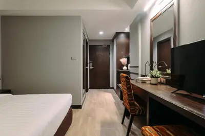 a bedroom with a bed and a desk with a television at Tori crown hotel in Bangkok