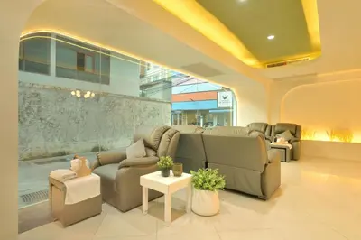 a waiting room with couches and chairs in a building at Tori crown hotel in Bangkok