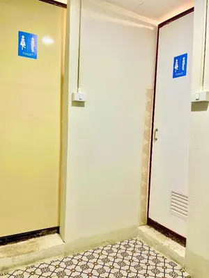 a bathroom with a door and a tile floor at Rhythm of life guesthouse 56 in Bangkok