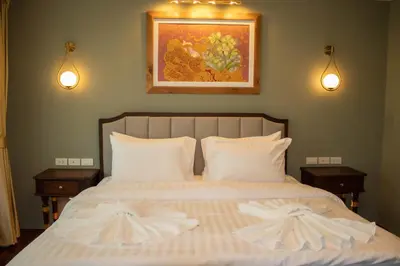 a bedroom with a bed with two towels on it at Siri Grand Bangkok Hotel in Bangkok