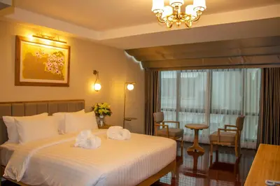 a hotel room with a bed with towels on it at Siri Grand Bangkok Hotel in Bangkok