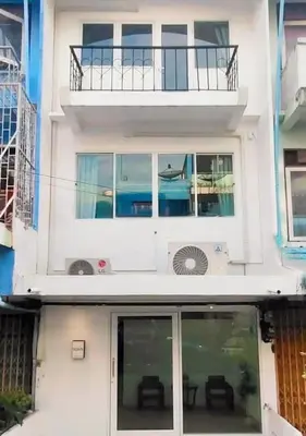 a white house with windows and a balcony at Nitichai Place, Private Sukhumvit Townhome 8PAX in Bangkok