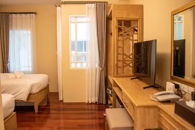 a bedroom with a bed and a television in a room at Siri Ratchadamnoen Bangkok Hotel in Bangkok