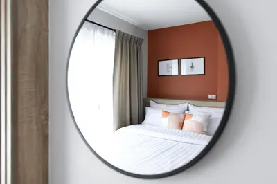 a bedroom with a bed and a mirror at You Hotel in Ban Zong Katiam