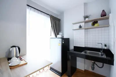 a kitchen with a sink and a refrigerator at You Hotel in Ban Zong Katiam