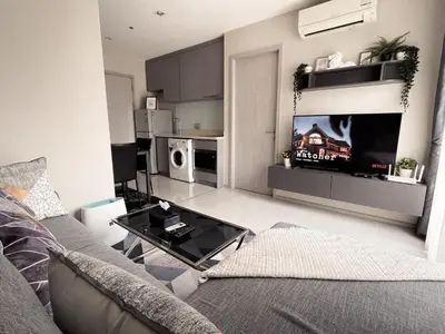 a living room with a couch and a tv at Luxurious Downtown condo w/train access in Bangkok