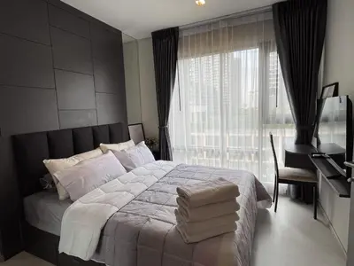 a bedroom with a large bed and a window at Luxurious Downtown condo w/train access in Bangkok