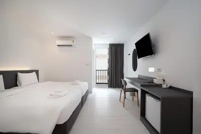 a hotel room with a large bed and a desk at The Urban Oasis in Bangkok