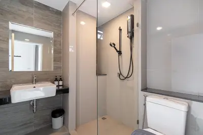 a bathroom with a sink and a toilet and a mirror at The Urban Oasis in Bangkok