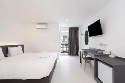 a bedroom with a bed and a desk and a tv at The Urban Oasis in Bangkok